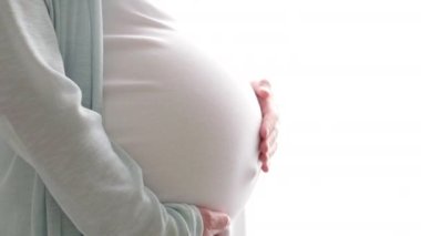 Hamile hamile bir anne karnını okşarken. Kadın elleri karnına dokunuyor, bekliyor. Doğum hazırlığı, büyük göbekli bir kız..