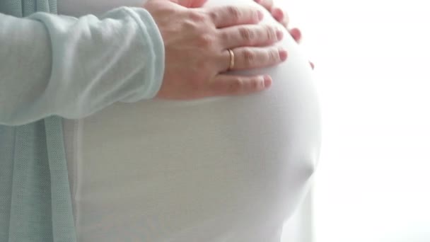 4k Pregnant expectant mother caressing her belly. Woman hands touching her tummy, waiting child. Preparation for childbirth, Girl big belly advanced pregnancy. — Stock Video