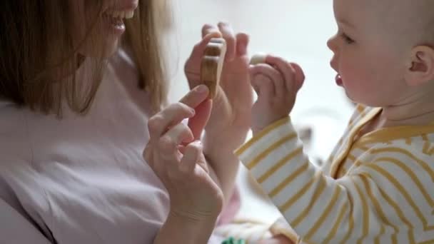 Kleine baby meisje en mama spelen thuis houten eco speelgoed. Moeder en dochter lachen samen plezier — Stockvideo