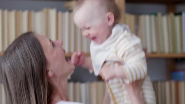 Kleine baby kind lachen plezier hebben en kijken in de camera. Gelukkige Vrolijke Familie. Moeder en baby zoenen. — Stockvideo