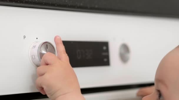 Kind drückt Ofenknopf. Neugierige kleine Baby öffnet Backofen zu Hause in der Küche. Kleiner Helfer für Mama. Sicherheit und Schutz von Kindern. — Stockvideo