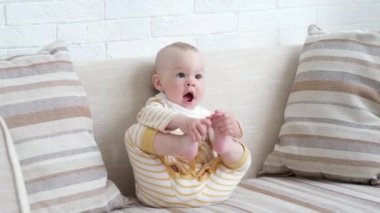 Çocuğun ilk adımları. Sevimli küçük bebek, ailesinin yardımı olmadan ilk kez kanepeye tırmandığı için mutlu. Çocuk büyümesi, çocuğun ilk fiziksel başarıları.