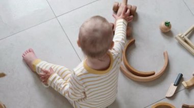 Top View Eko oyuncağı bebek oyunu. Küçük zeki beyaz çocuk evde yerde doğal oyuncaklar oynuyor. Erken gelişim için eğitici oyunlar.