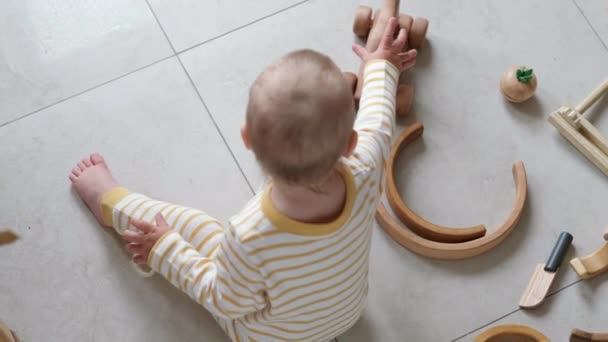 Vue de dessus jouet en bois écologique jeu de bébé. Petit enfant caucasien intelligent jouant des jouets naturels sur le sol à la maison. Jeux éducatifs pour le développement précoce. — Video