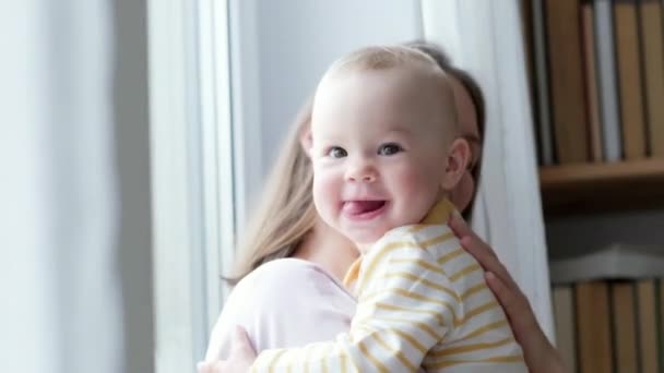 Kleine baby kind lachen plezier hebben en kijken in de camera. Gelukkige Vrolijke Familie. Moeder en baby zoenen. — Stockvideo