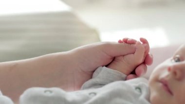4k Yeni Doğmuş Bebek El Ele Tutuşan Anne, Anne minicik ellerine dokunarak ona sevgisini hissettirdi, sıcak ve güvenli. Annelik, aile, doğum kavramı