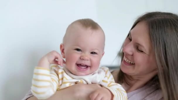 Kleine baby kind lachen plezier hebben en kijken in de camera. Gelukkige Vrolijke Familie. Moeder en baby zoenen. — Stockvideo