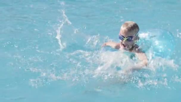 Маленький хлопчик у басейні, дитина розважається, сидить на синьому плавальному кільці, грає під водою. Літні подорожі сімейний готель відпочинок туристів . — стокове відео