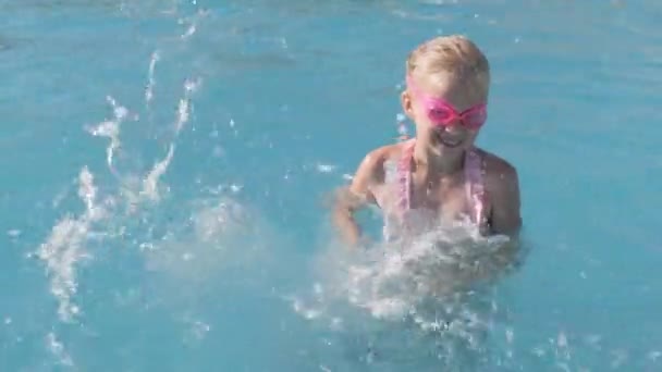 Niña nadando en la piscina, niño divirtiéndose, salpicando agua, saltando. Verano viajes familia hotel vacaciones turistas. — Vídeos de Stock