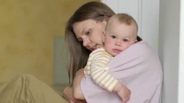 Mãe balançando seu bebê antes de ir para a cama. criança infantil em mãos de mãe. A mãe está a tentar acalmar o bebé. Vida familiar, maternidade — Vídeo de Stock