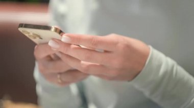 4 bin. iPhone 12 akıllı telefonu kullanan bir kadın parmak basıyor, sosyal medya interneti okuyor, mesaj yazıyor ya da internetten alışveriş yapıyor. Cep telefonu evde iki kızın elinde ya da 26.08.21 St. Petersburg Rusya 'da çalışıyor.