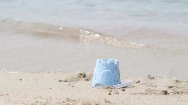 Okyanus sahilinde bebek kum kovası. Çocuk kumdan kale inşa ediyor. Sıcak ülkelere aile tatili, seyahat, turizm.