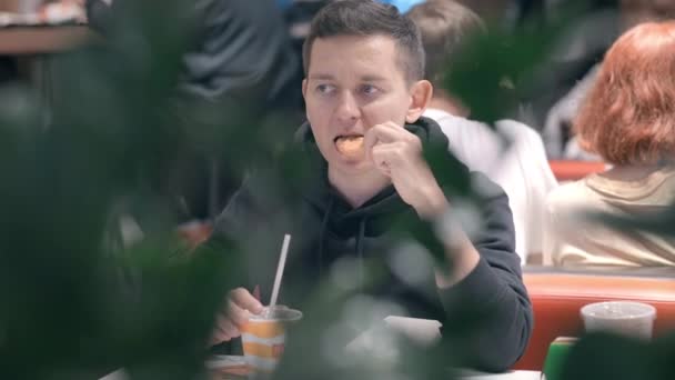 Man Student isst Nuggets, Pommes und trinkt Cola in McDonalds Fast-Food-Restaurant. Ungesunde Ernährung, Snacks, Junk Food. 26aug2021 Sankt Petersburg Russland — Stockvideo