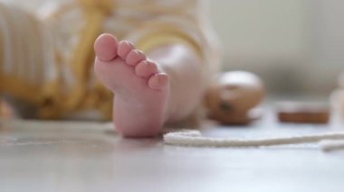 Bebek ayağını kapat. Küçük zeki beyaz çocuk evde yerde doğal oyuncaklar oynuyor. Erken gelişim için eğitici oyunlar. Eko ahşap oyuncak bebek oyunu.