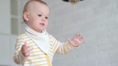 Küçük bebek mutfakta dans ediyor ve çocukların şarkılarını dinliyor. Mutlu bir çocukluk