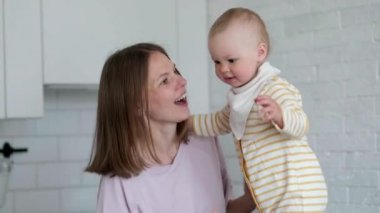 Küçük çocuk gülüyor, eğleniyor. Mutlu Neşeli Aile. Anne ve Bebek oynuyor.