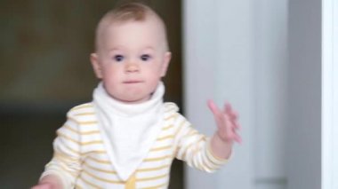 Küçük bebek mutfakta dans ediyor ve çocukların şarkılarını dinliyor. Mutlu bir çocukluk