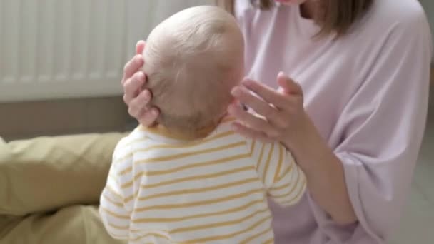 Mamma kramar och lugnar sitt gråtande barn Ett litet barn gråter framför kameran på mammas hand. Familjekärlek. — Stockvideo