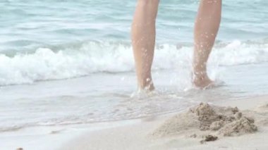 Çıplak ayaklı adam ayakları sahildeki okyanus suyunda yürüyor. Yaz tatili, tatil, aile gezisi. Sıcak ülkelere turizm