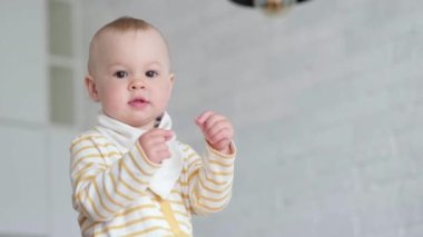 Küçük bebek mutfakta dans ediyor ve çocukların şarkılarını dinliyor. Mutlu bir çocukluk