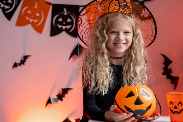 Halloween kids Portrait girl with pumpkin candy buckets in witch costume hat at home. Ready for trick or treat holiday. — Stock Photo, Image