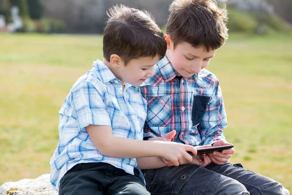 Little boys playing on tablet outdoor — Stock Photo, Image