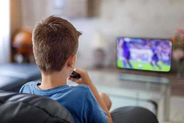 Aufgeregtes kleines Kind schaut Fußballspiel im Fernsehen — Stockfoto