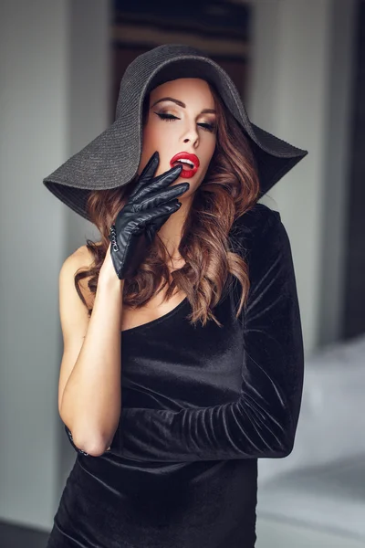 Чувственная женщина с красными губами в шляпе и перчатках — стоковое фото