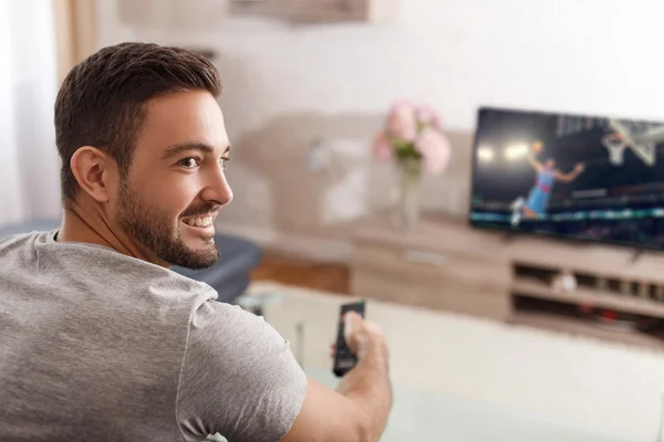 Excited man switch TV to basketball — Stock Photo, Image