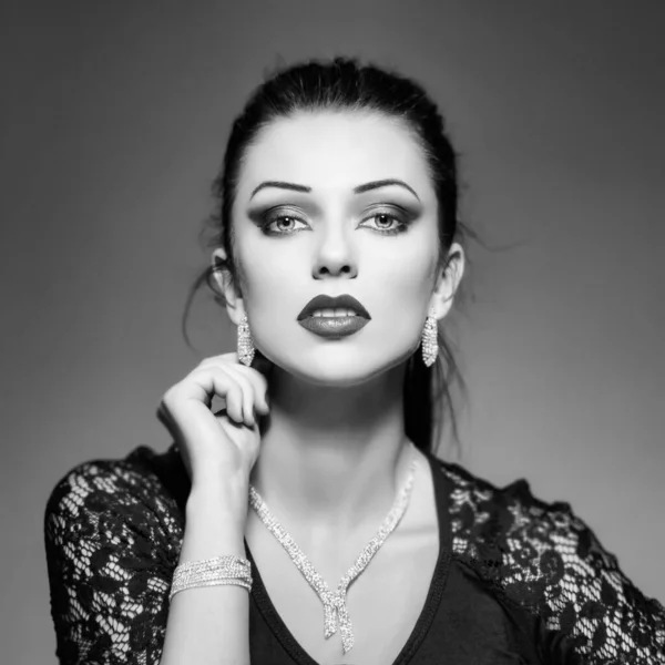 Beautiful woman with necklace and bracelet and earrings portrait, black and white