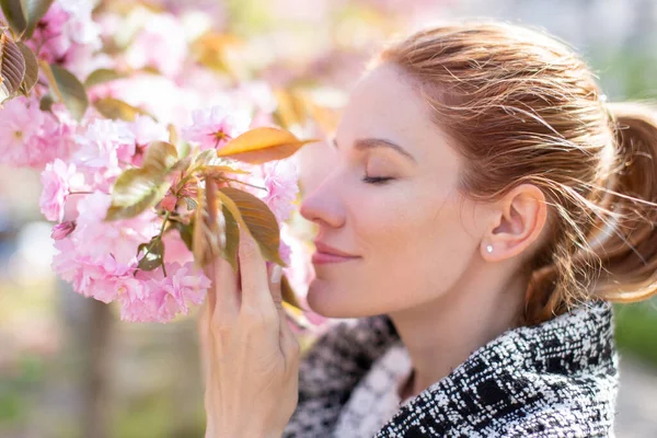 Young Positive Woman Smelling Cherry Blossom Profile View Eyes Closed — Stock Photo, Image