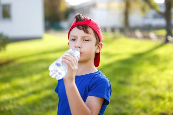 Kleine jongen drinkwater uit fles — Stockfoto