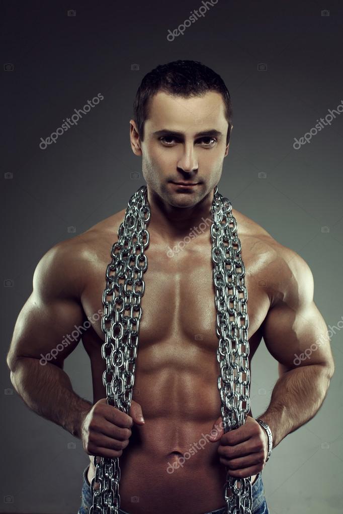 Sexy muscular hombre desnudo con cadenas fotografía de stock sakkmesterke