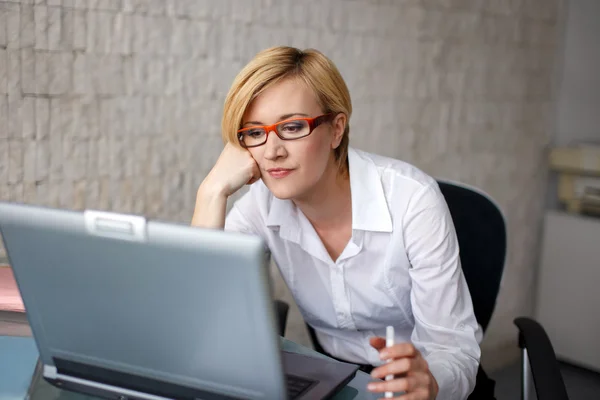 Blonde businesswoman in glasses waiting for message — Stock Photo, Image