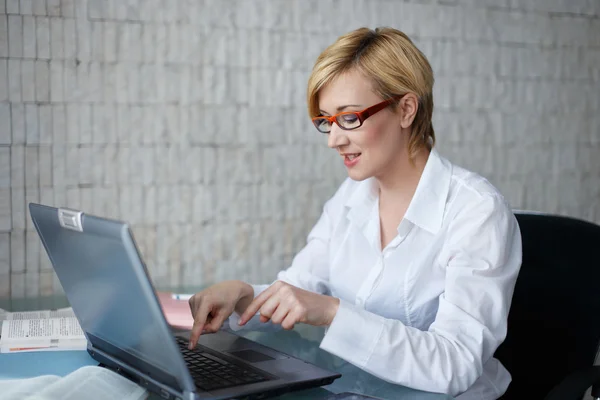 Mujer de negocios rubia en gafas escribiendo — Foto de Stock