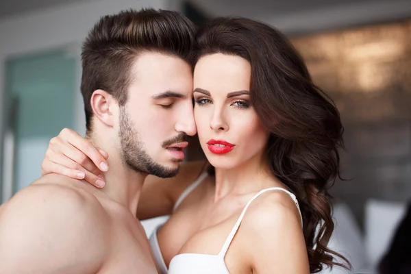 Sensual woman with red lips in hotel room with young lover — Stock Photo, Image