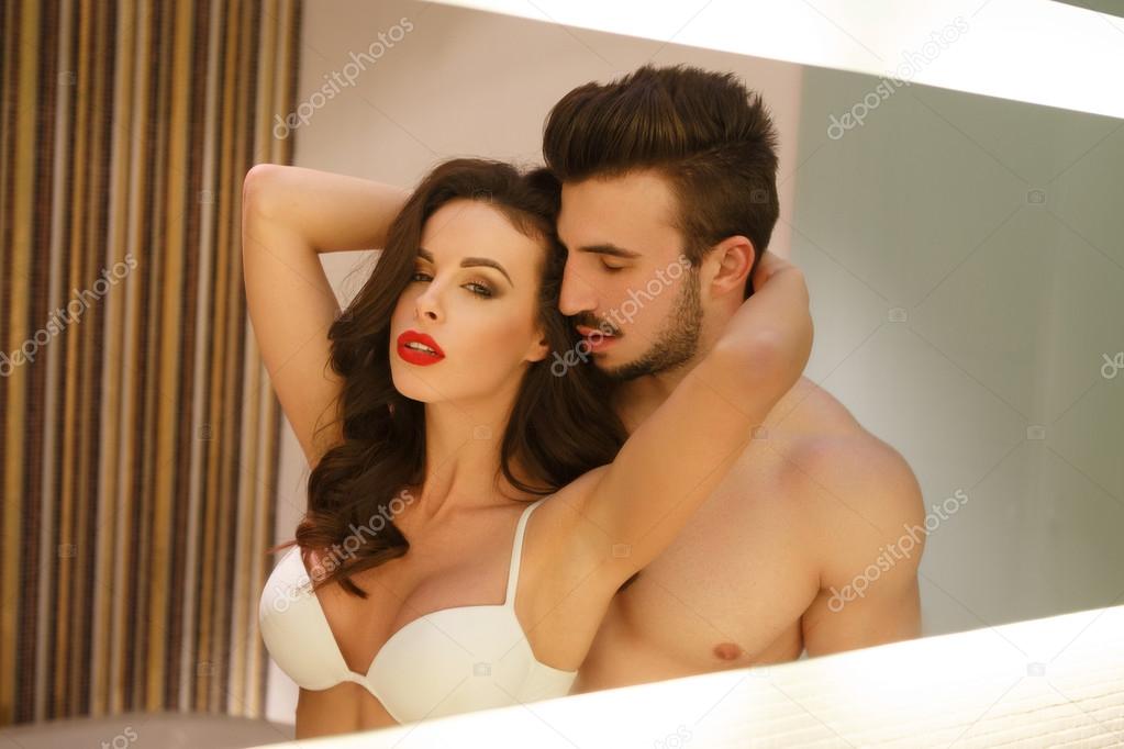 Sexy passionate couple posing at mirror