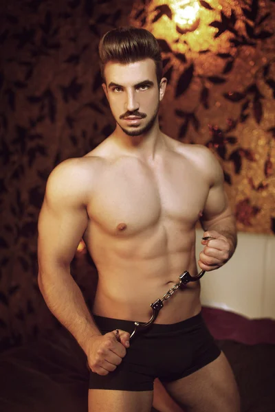 Uomo macho sexy con manette in camera d'albergo — Foto Stock