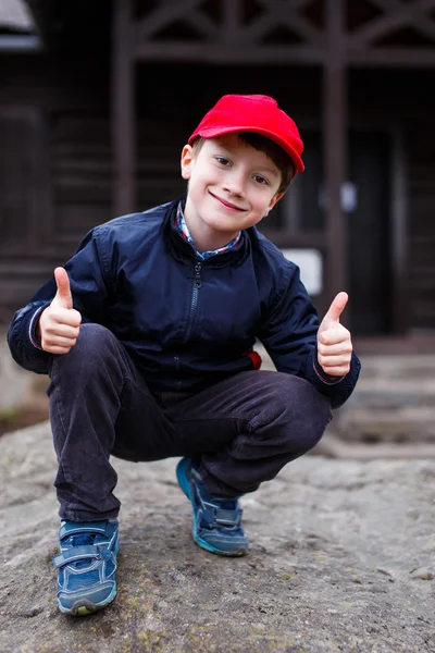 Liten skolpojke tummen upp utomhus — Stockfoto