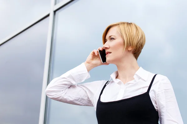 Blonde businesswoman calling by smartphone — Stock Photo, Image