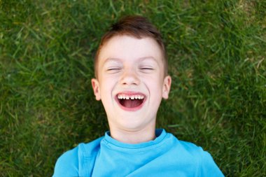 Küçük çocuk çimenlerde gülüyor