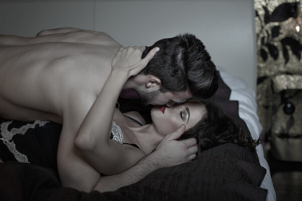Passionate couple kissing in bed