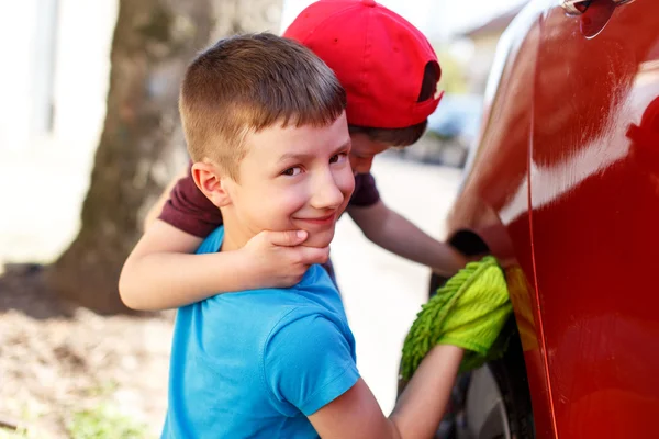 Kleine jongens splash guard op auto wassen — Stockfoto