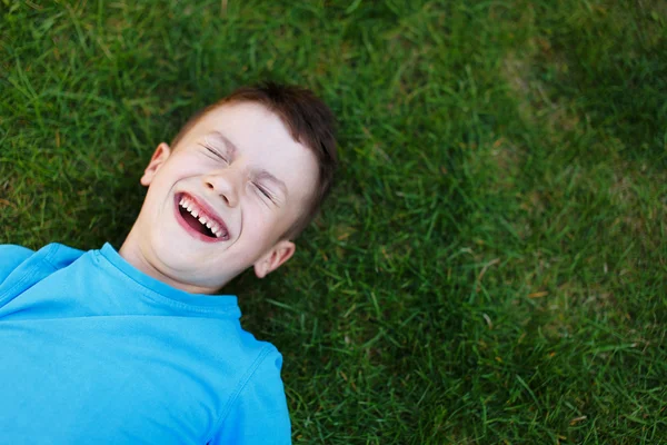 Kleine jongen lachen in gras — Stockfoto