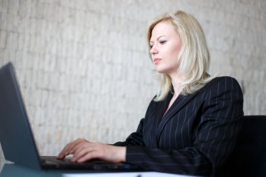 Sarışın işkadını dizüstü bilgisayarda yazarak