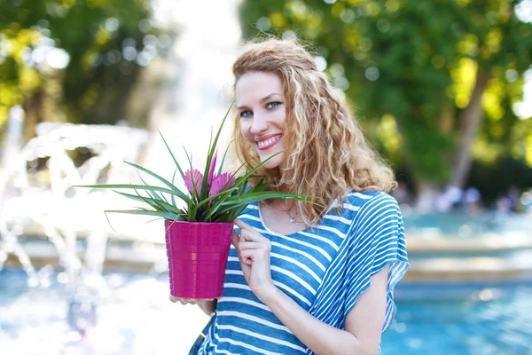 Young woman with curly hair with bromelia — Stock Photo, Image