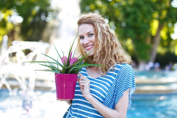 Mujer joven con pelo rizado con bromelia —  Fotos de Stock