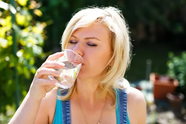 Femme blonde boire de l'eau en plein air — Photo