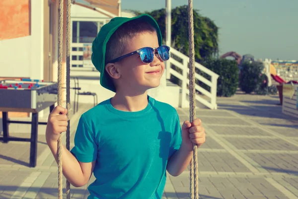 Liten pojke svängande utomhus på sommaren dag vintage stil — Stockfoto