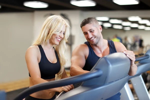 Personal Trainer stellt Schwierigkeit auf Laufband für Frau — Stockfoto